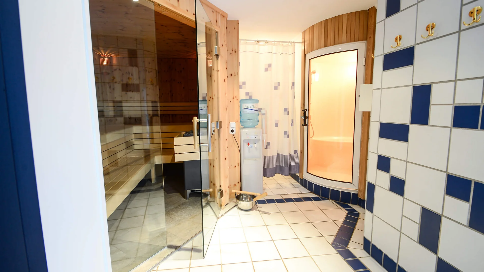 Hotel Kogler **** © Armin Ribis Wellnessbereich mit Holzsauna hinter Glastür und blau-weißen Fliesen