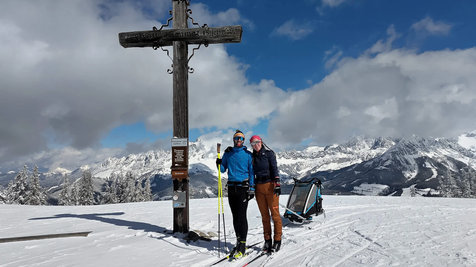 Cross-country skiing holiday in the Tennengau region Two skiers stand by a large wooden cross in snowy mountains