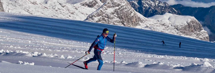 Schladming-Dachstein © Felgenhauer/xc-ski.de Skilangläufer trainiert auf schneebedecktem Berg mit Alpen im Hintergrund