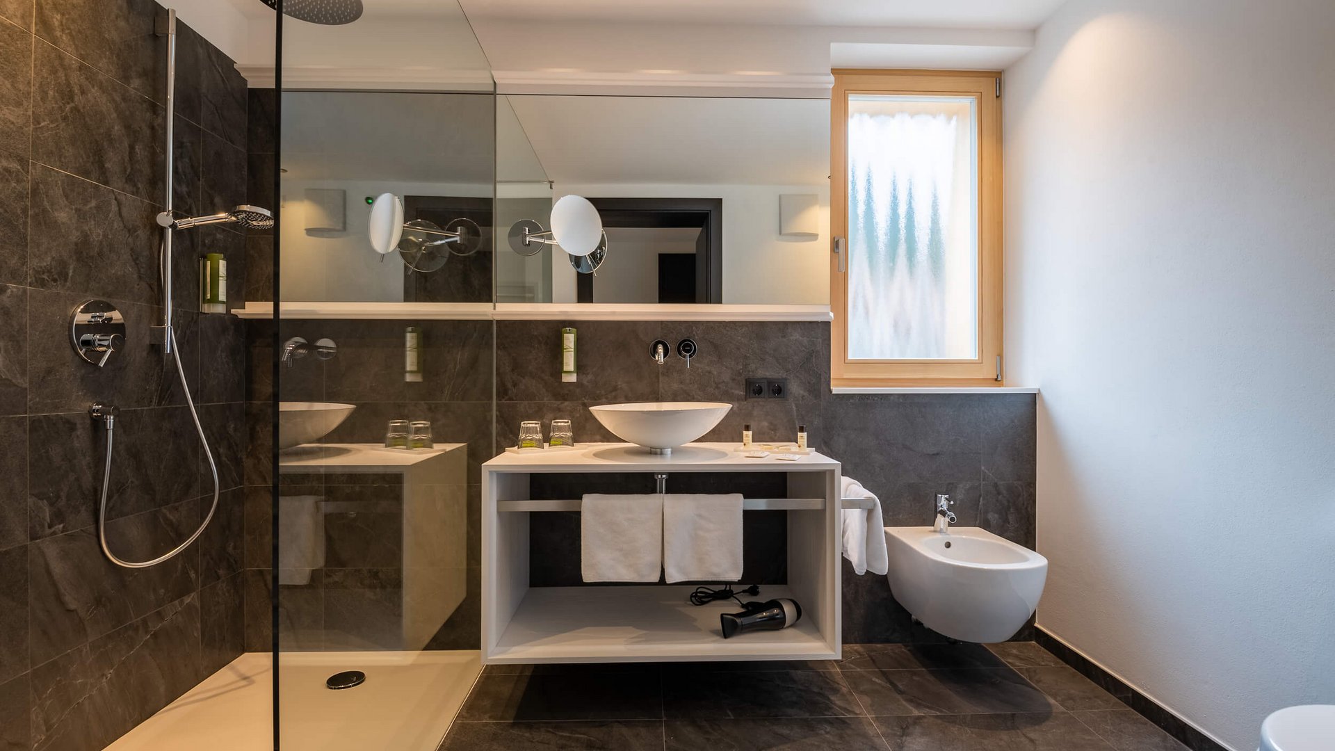 Moderner Badezimmerbereich mit Dusche, Waschbecken und Bidet