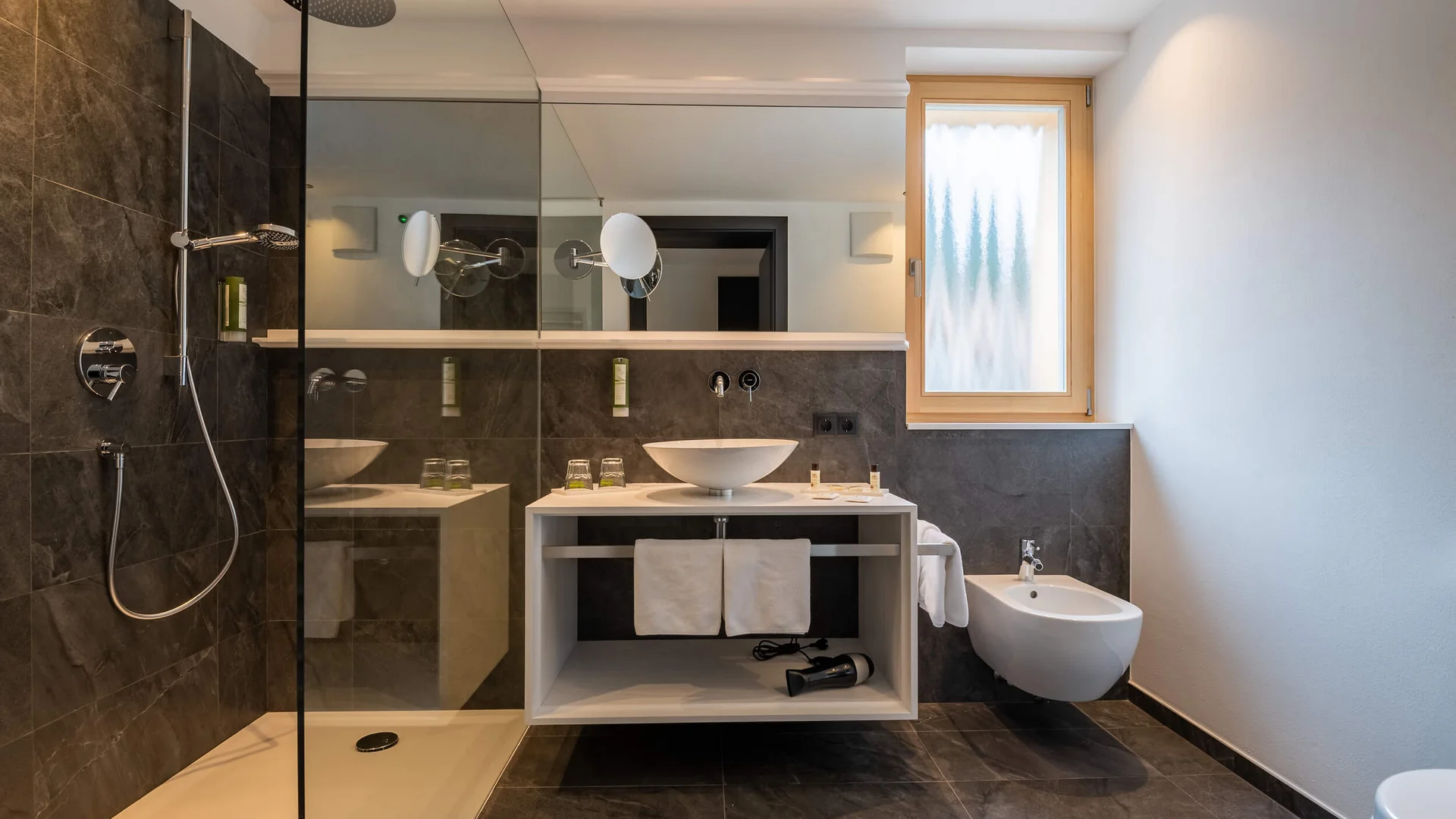 Hotel Brunnerhof © Hotel Brunnerhof der Brunner Christina & Co. KG Moderner Badezimmerbereich mit Dusche, Waschbecken und Bidet