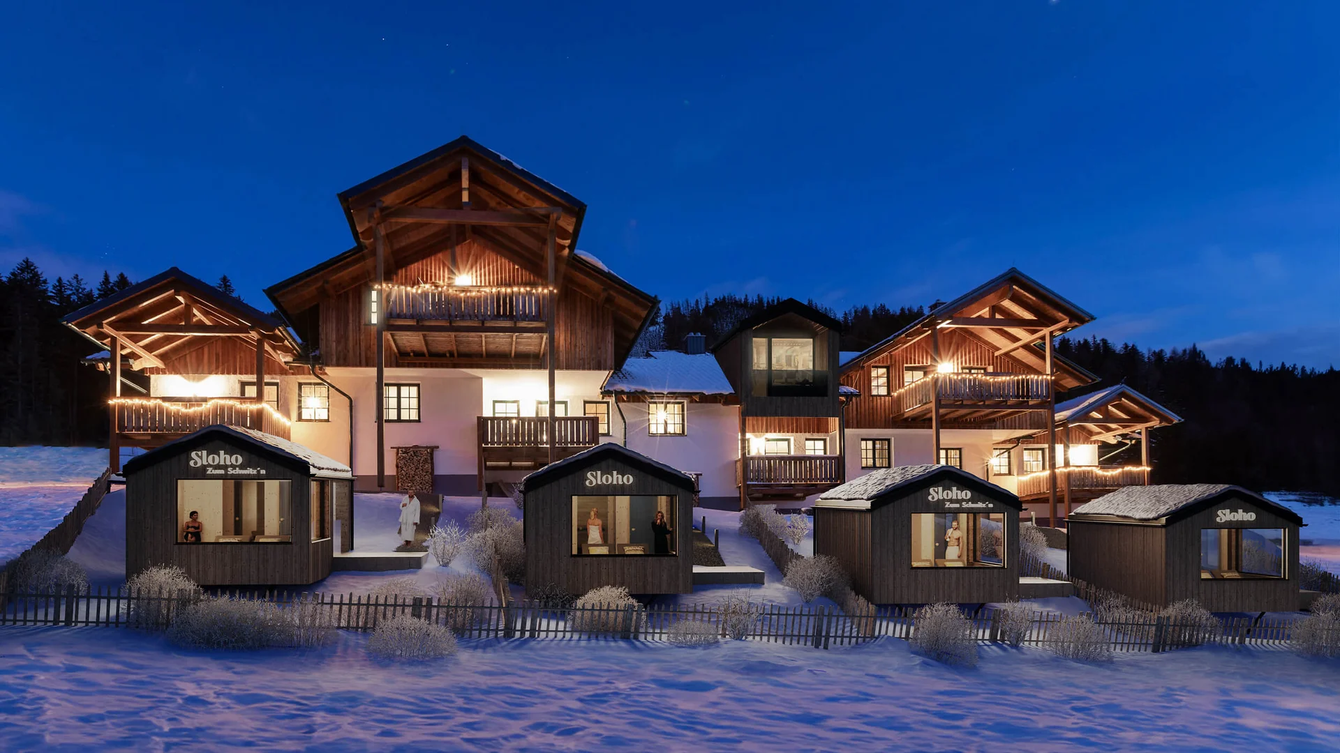 SLOHO Bergurlaub Apartments © Cathrine Stukhard Beleuchtete Holzhäuser in einer verschneiten Anlage bei Dämmerung