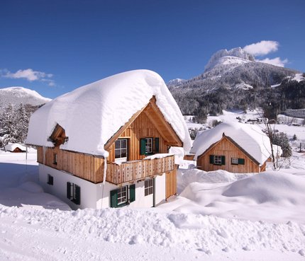 Hüttendorf – Aktiv & Naturresort AlpenParks Hagan Lodge © Gerhard Wolkersdorfer Holzhäuser mit dicken Schneeschichten im Winter in den Bergen