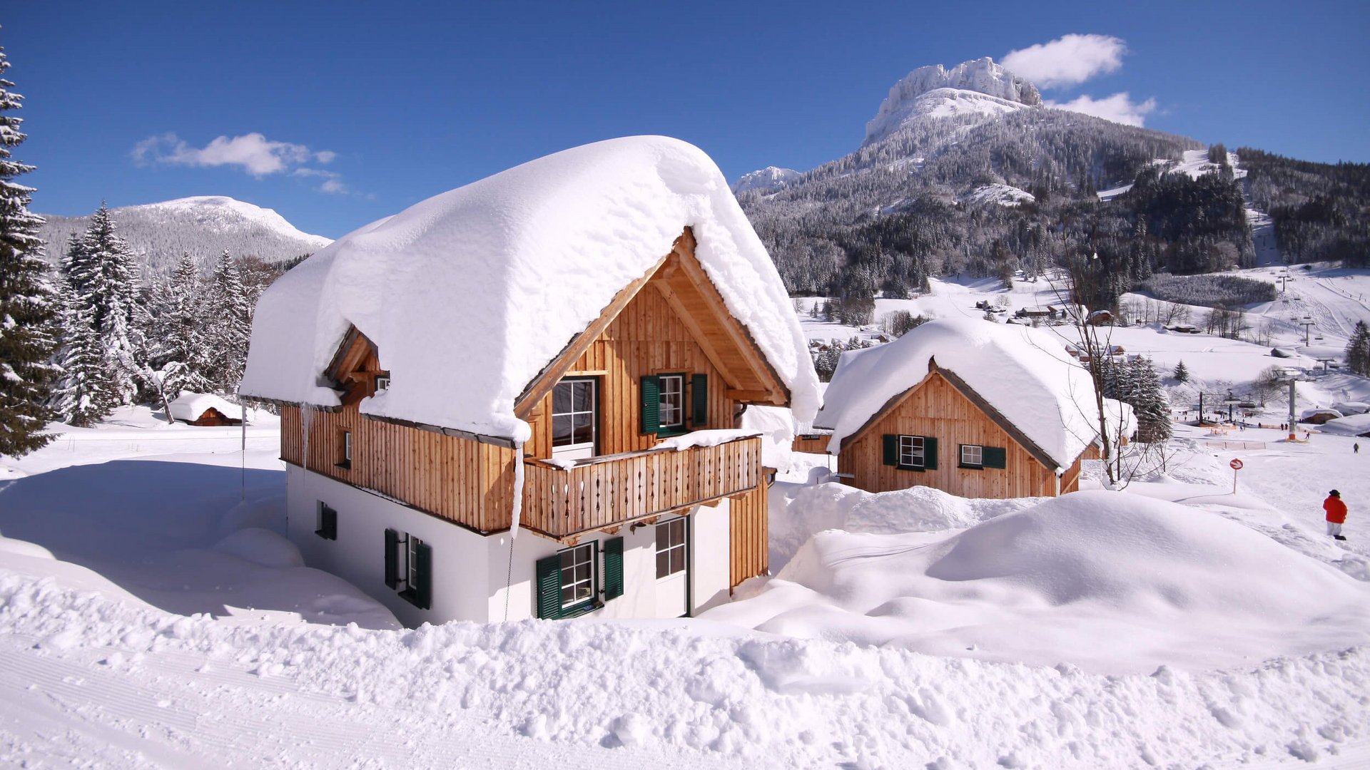 Wooden houses covered in thick snow in a mountain winter landscape