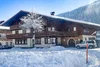 Sammelanfragen © Auszeit Filzmoos - Kai-Uwe Wagner Schneebedecktes Chalet mit Baum und Autos in winterlicher Berglandschaft
