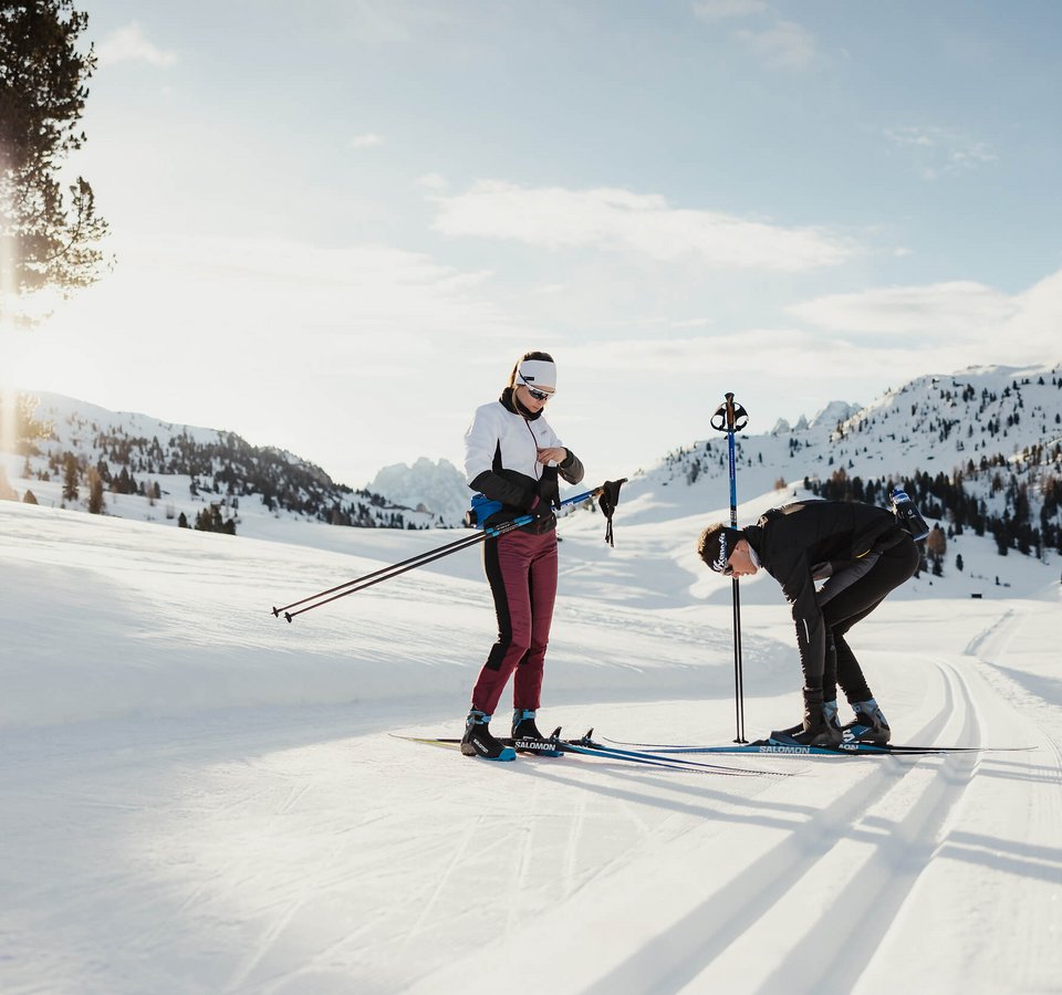 Fit auf die Loipe mit Christina Rieder © Alex Moling Zwei Menschen bereiten sich auf Langlauf in verschneiter Berglandschaft vor