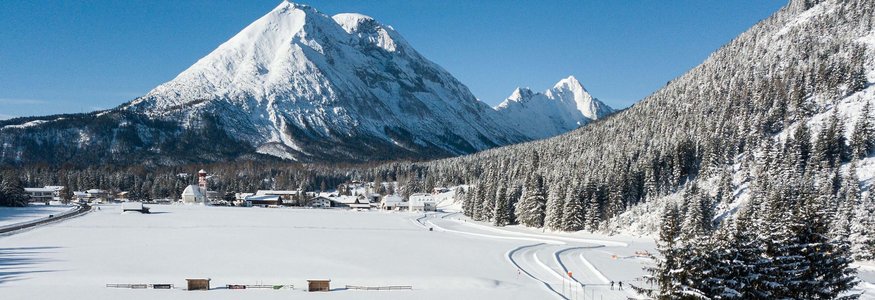 Verschneite Landschaft mit Bergen, Wald und Langläufern in Leutasch