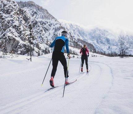 Slowenien: Geheimtipp für Nordische Wintersportler © Ciril Jazbec Zwei Langläufer auf verschneiter Loipe in bergiger Winterlandschaft