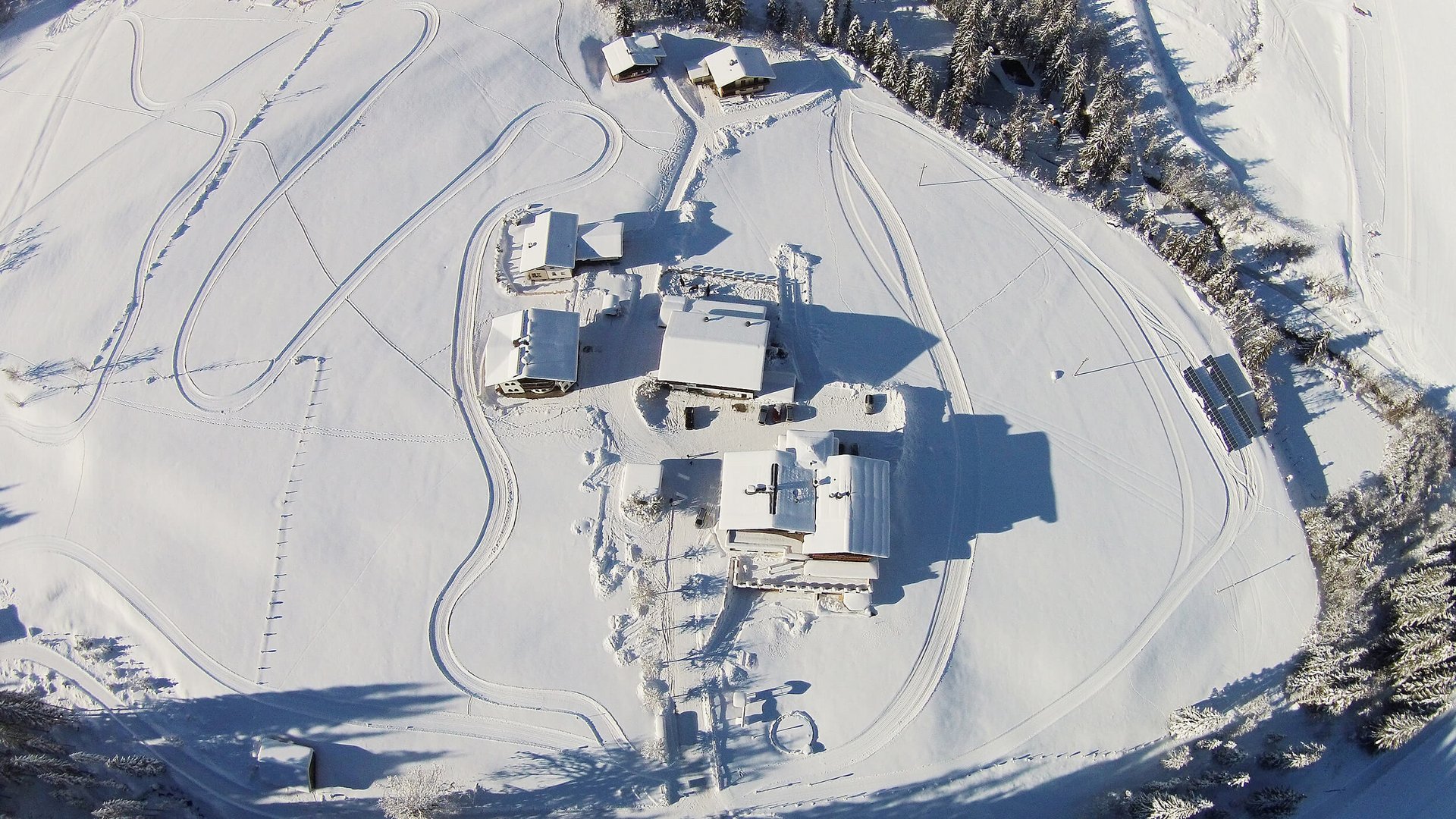 Luftaufnahme von Häusern im verschneiten Winterwald