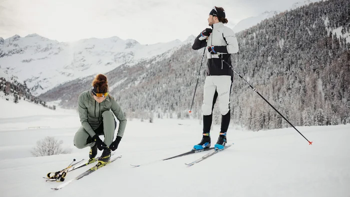 Zwei Langläufer bereiten sich im verschneiten Gebirge vor