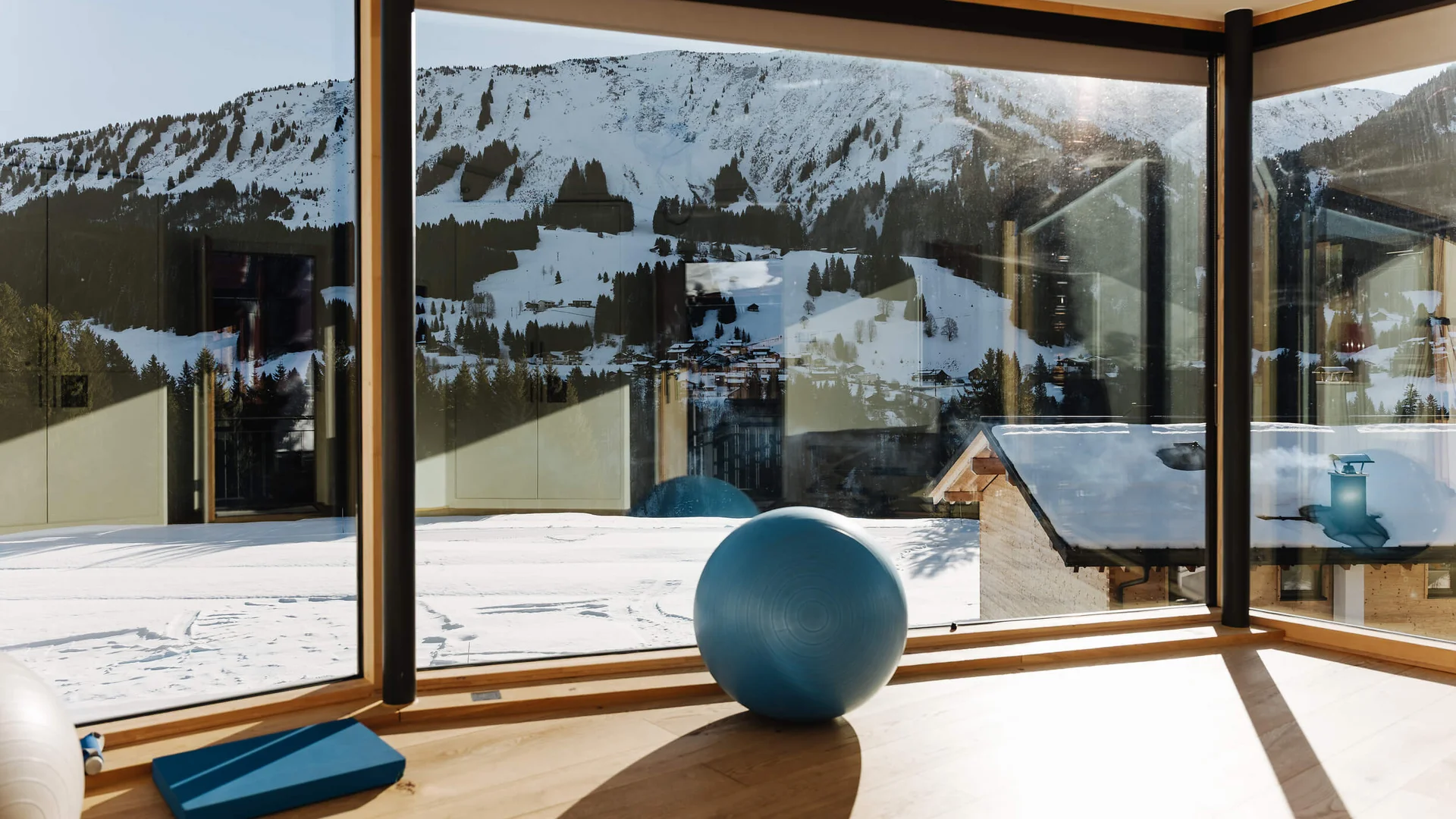 Genuss- und Aktivhotel Sonnenburg **** © Elisa Moosbrugger Heller Fitnessraum mit Gymnastikball, Matten und Blick auf verschneite Berge