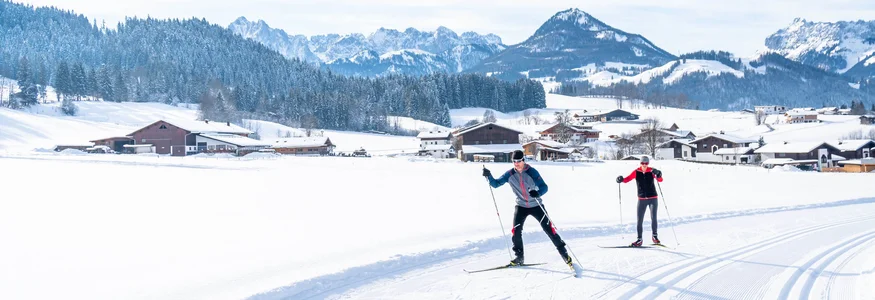 Die Kaiserwinklloipe © Tourismusverband Kaiserwinkl Zwei Langläufer auf verschneiter Loipe in alpiner Winterlandschaft