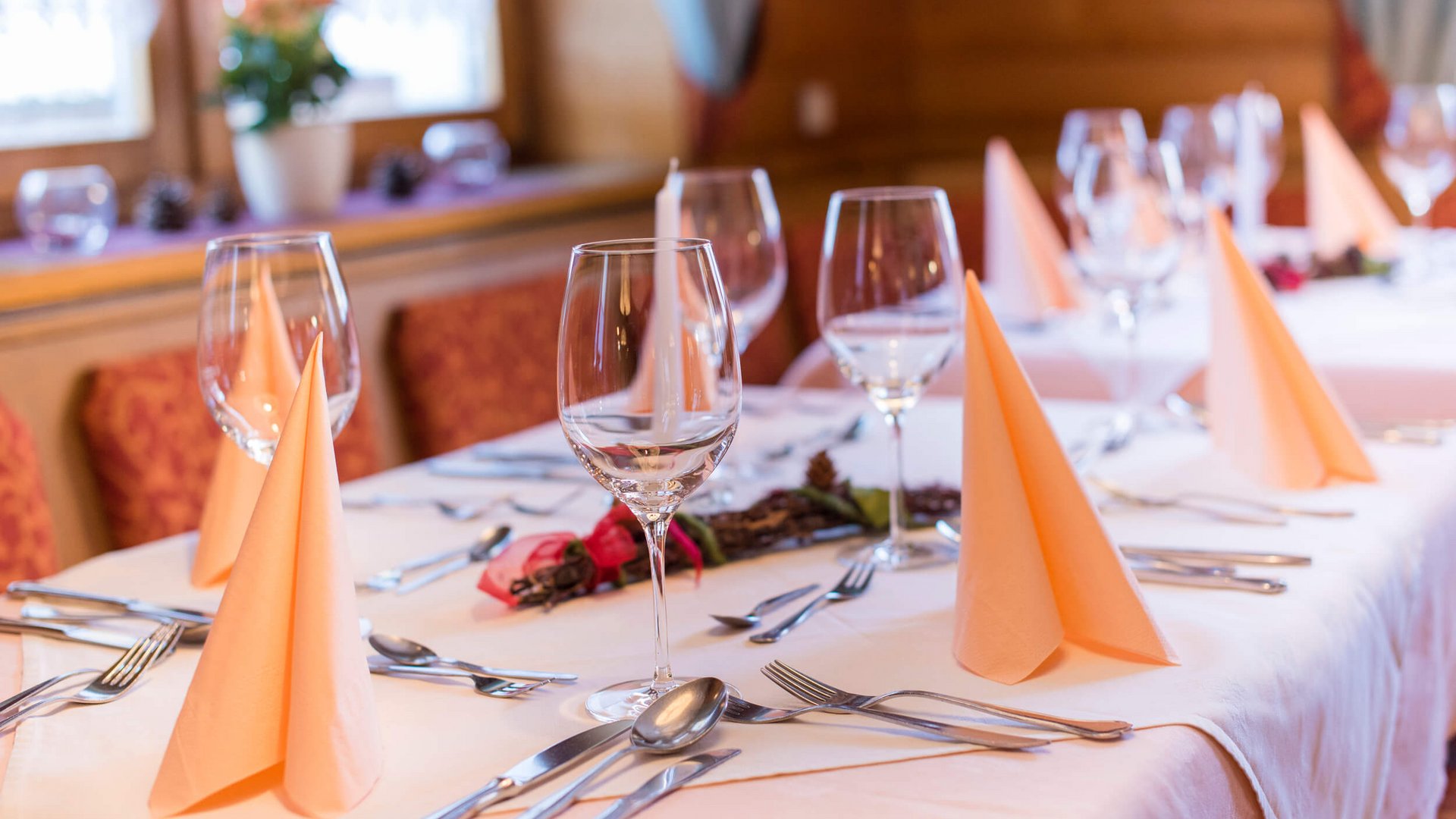 Elegantly set dining table with wine glasses and folded napkins in cozy restaurant
