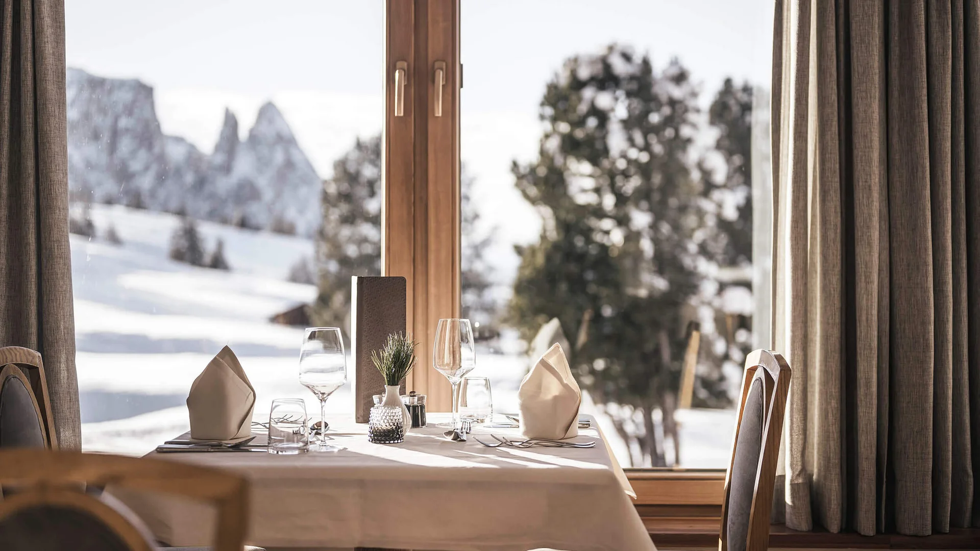 Tisch im Restaurant mit Blick auf verschneite Berge am Fenster
