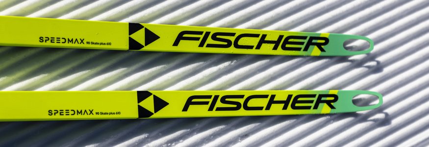 Zwei gelb-grüne Fischer Speedmax Langlaufski auf präparierter Loipe