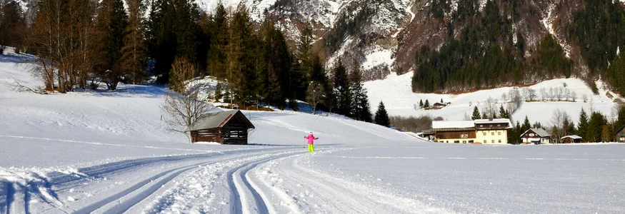 Tennengau Cross-country ski tracks in snow with mountains and houses in background