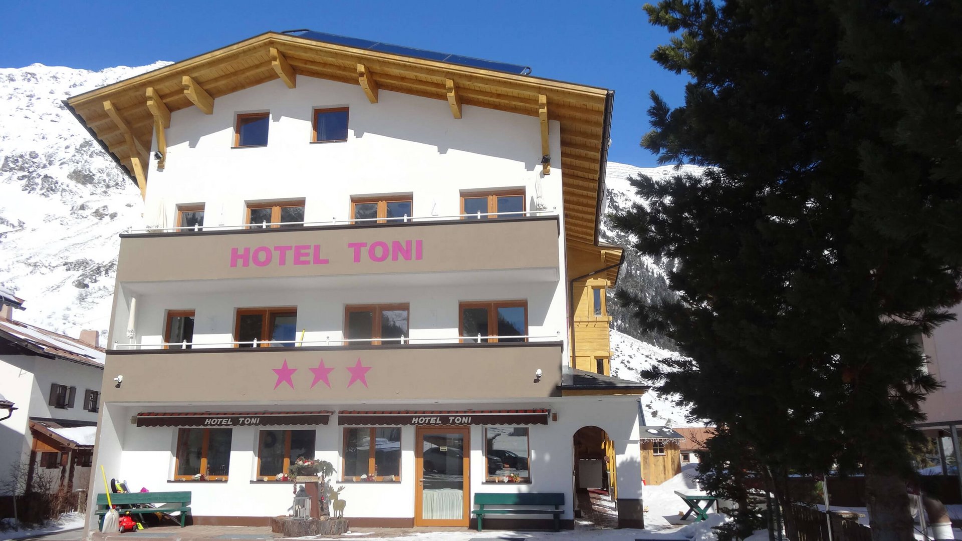 Exterior of Hotel Toni with mountains and snow in the background