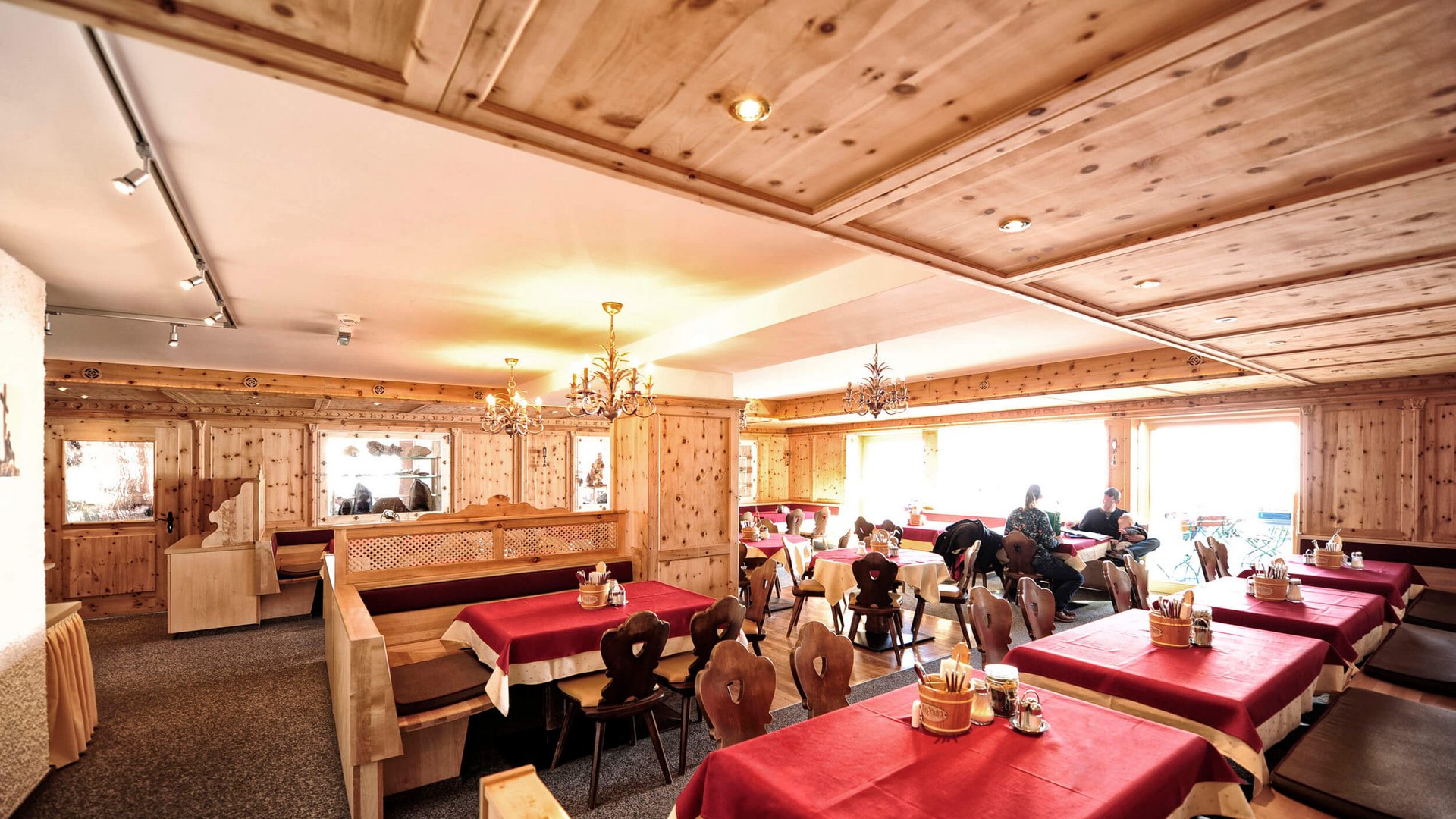 Restaurant interior with wooden furniture and red tablecloths