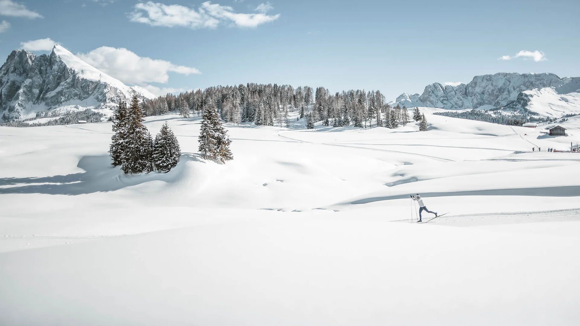 Skifahrer in verschneiter Berglandschaft mit blauen Himmel