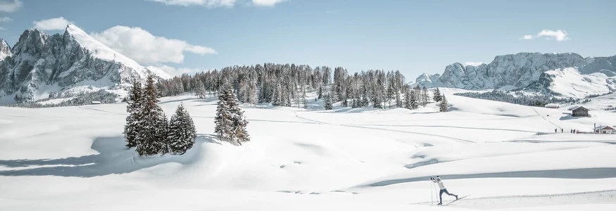 Skifahrer in verschneiter Berglandschaft mit blauen Himmel