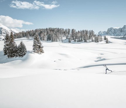Skifahrer in verschneiter Berglandschaft mit blauen Himmel