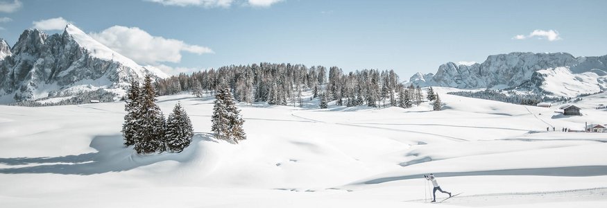 Best of Dolomitenregion Seiser Alm © Dolomiti Nordic Ski - Manuel Kottersteger Skifahrer in verschneiter Berglandschaft mit blauen Himmel