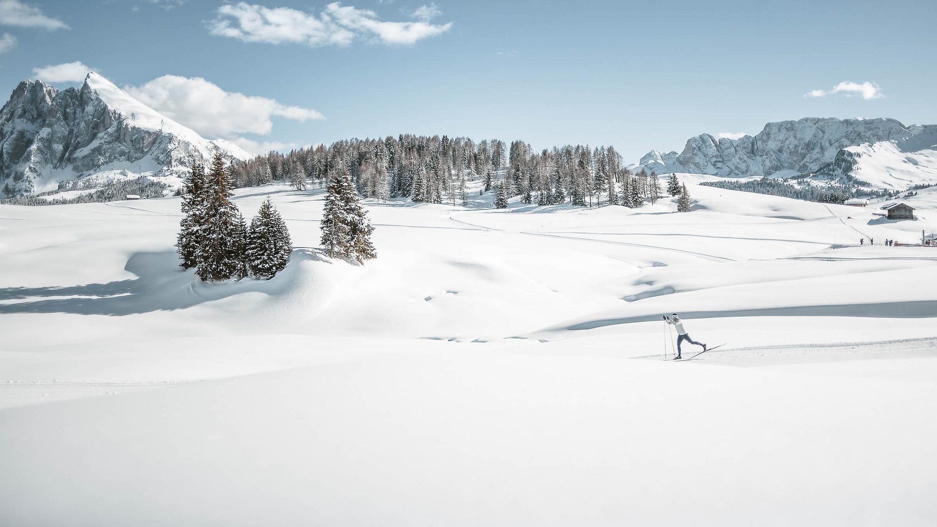 Skifahrer in verschneiter Berglandschaft mit blauen Himmel