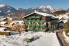 Sammelanfragen © Marcel Musiol Verschneites Dorf mit traditionellem grünem Gebäude vor Bergkulisse
