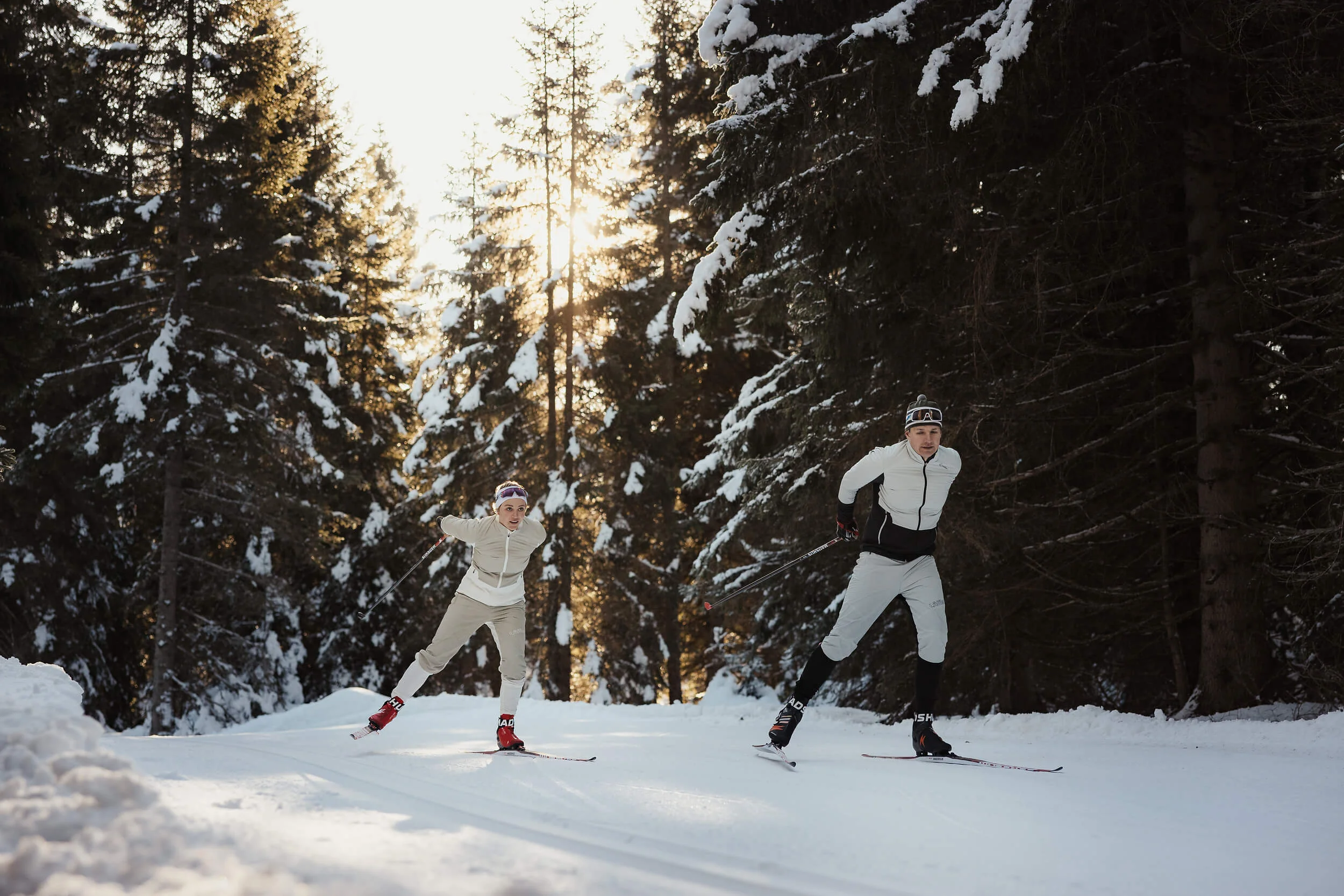 Austria © Alex Moling Two people cross-country skiing in snowy forest at sunlight