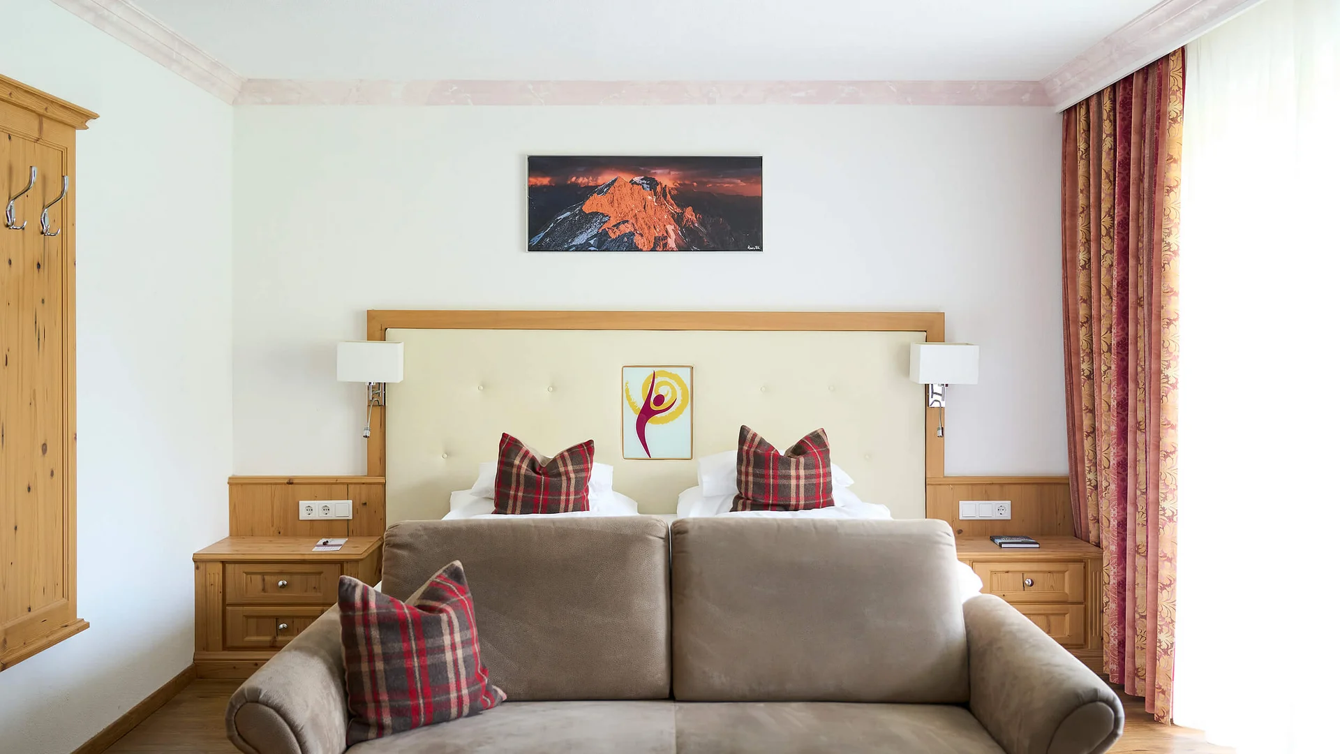 Hotel room with sofa, bed, nightstands, and curtains