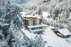 Sammelanfragen © Josef Plaickner Hotel in verschneiter Berglandschaft mit Tannenbäumen und Bergen im Hintergrund