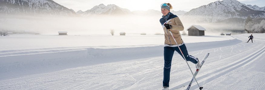 Woman cross-country skiing with snowy mountains in the background