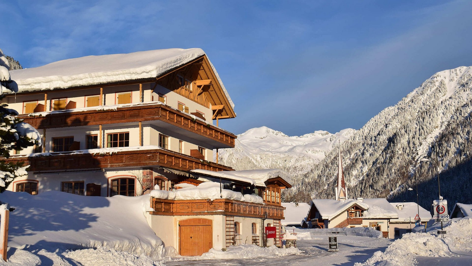 Schneebedecktes Chalet vor Berglandschaft in klarem Winterwetter