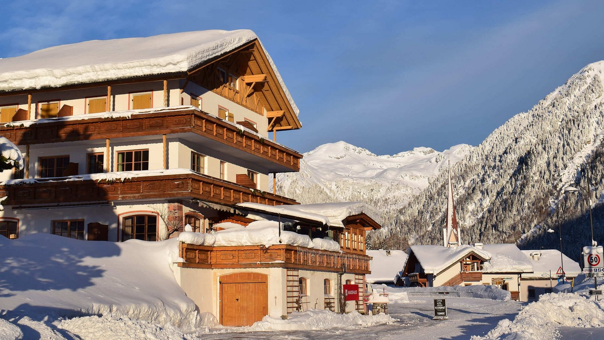 Schneebedecktes Chalet vor Berglandschaft in klarem Winterwetter