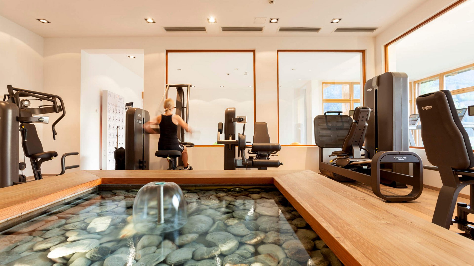 Modern gym room with water feature and exercise machines