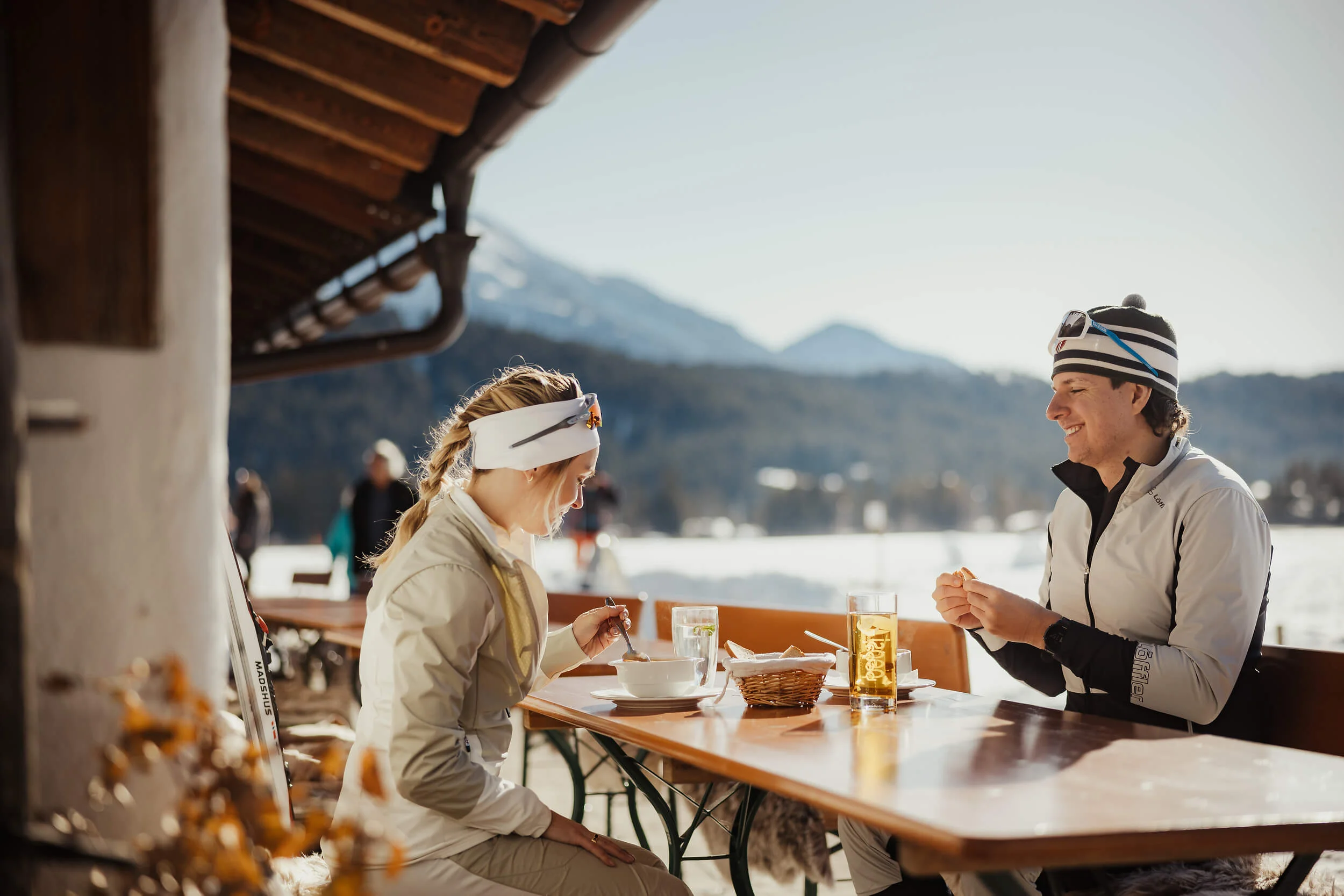 Österreich © Alex Moling Zwei Personen essen im Freien mit Bergen und Schnee im Hintergrund