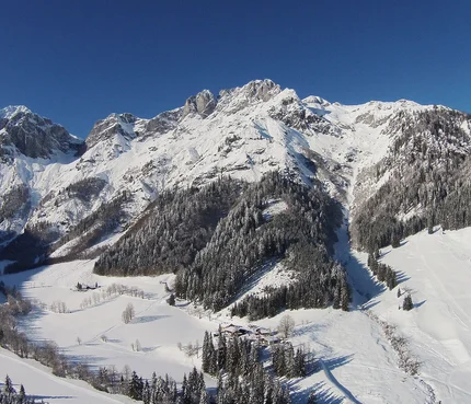 Schneebedeckte Berge und Täler unter klarem blauem Himmel