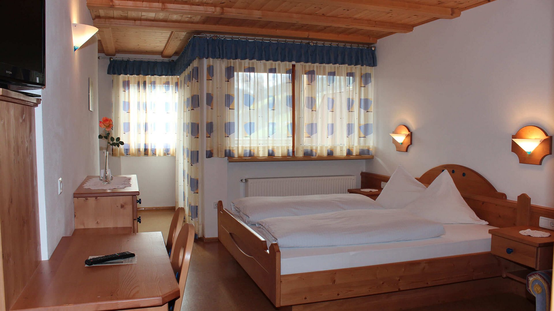 Gemütliches Hotelzimmer mit Doppelbett und Holzmöbeln