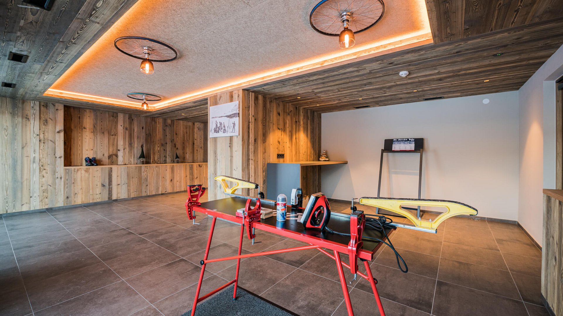 Moderne Skischuhwerkstatt mit Holzverkleidung und Werkzeugen auf rotem Arbeitstisch