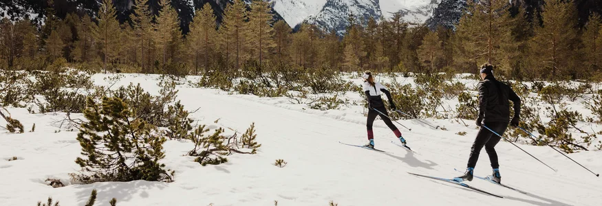 Hirben Naturlaub **** © Alex Moling Zwei Langläufer im verschneiten Gebirgstal vor schneebedeckten Bergen