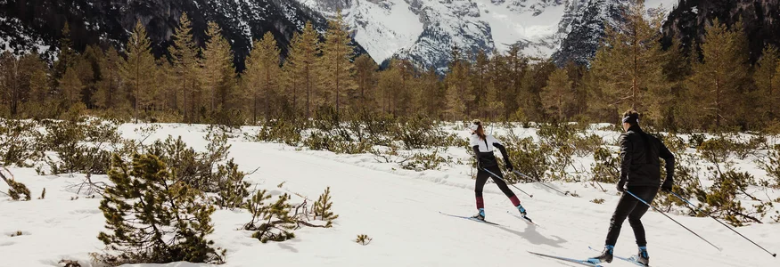 Trainieren wie die Profis in den Drei Zinnen © Alex Moling Zwei Langläufer im verschneiten Gebirgstal vor schneebedeckten Bergen