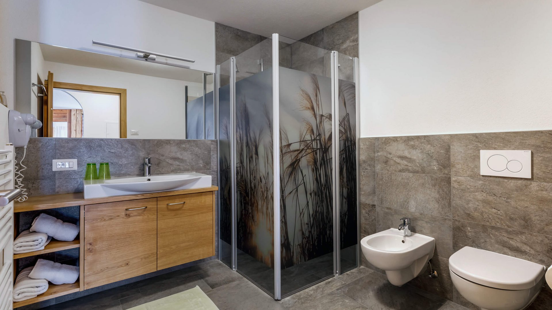 Modernes Badezimmer mit Dusche, Waschbecken, Toilette und Bidet