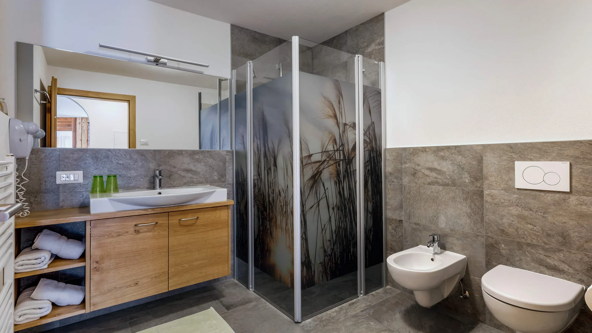 Modern bathroom with shower, sink, toilet, and bidet