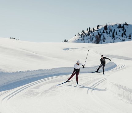 Trainieren wie die Profis in den Drei Zinnen © Alex Moling Zwei Personen beim Langlaufen auf verschneiter Bergstrecke unter klarem Himmel