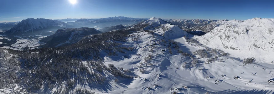 Panoramic view of snow-covered mountains and valleys under clear sky