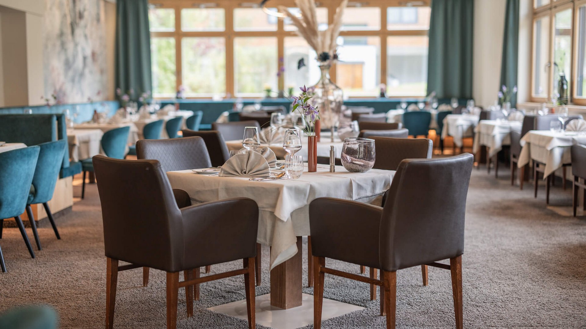 Elegant restaurant interior with set tables and brown armchairs