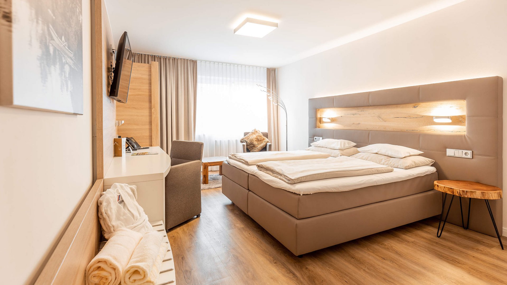 Modern hotel room with double bed and wooden floor
