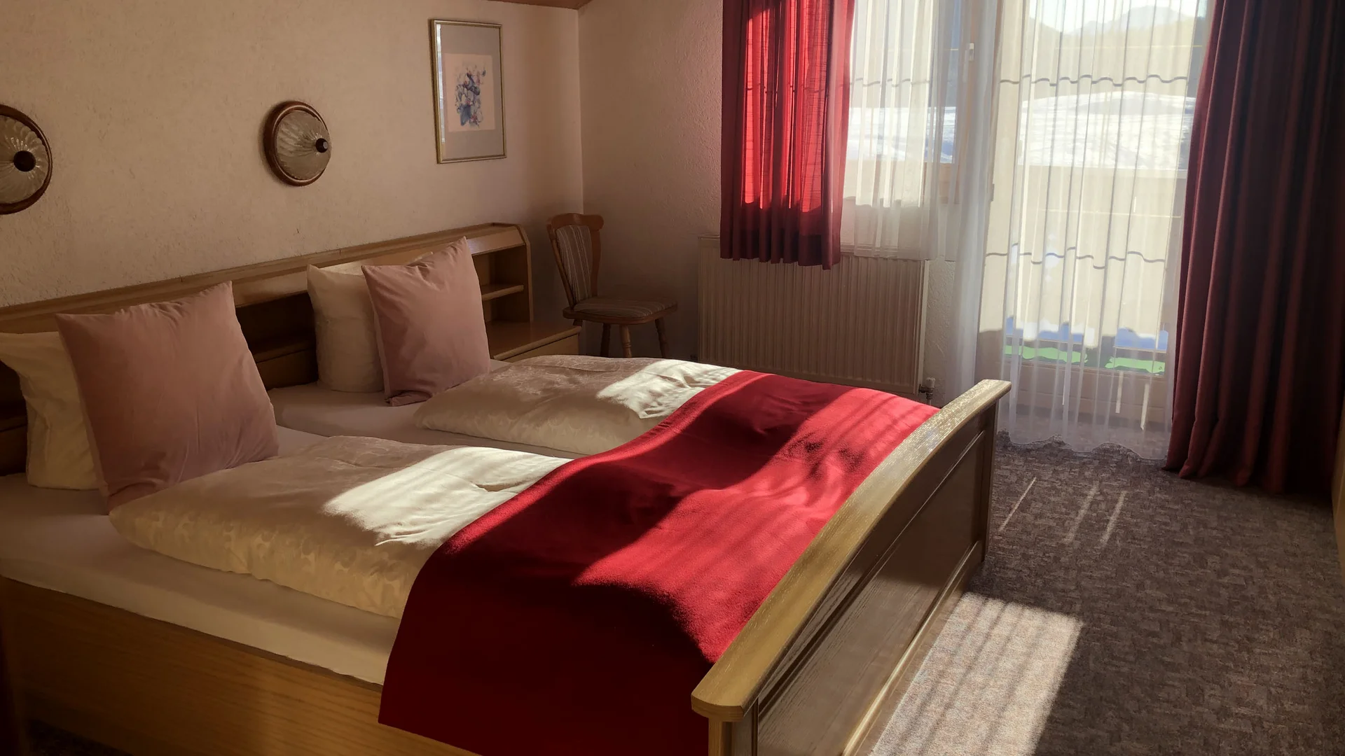 Haus Anemone *** © Familie Moncher Gemütliches Schlafzimmer mit Doppelbett und rotem Bettüberwurf