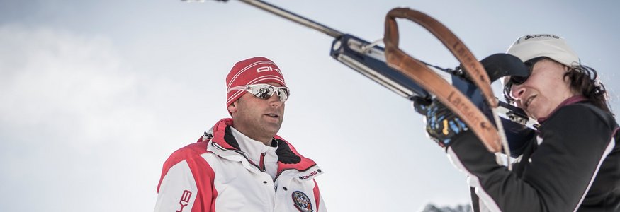 Trainer beobachtet Frau beim Biathlon-Schießen in den Bergen