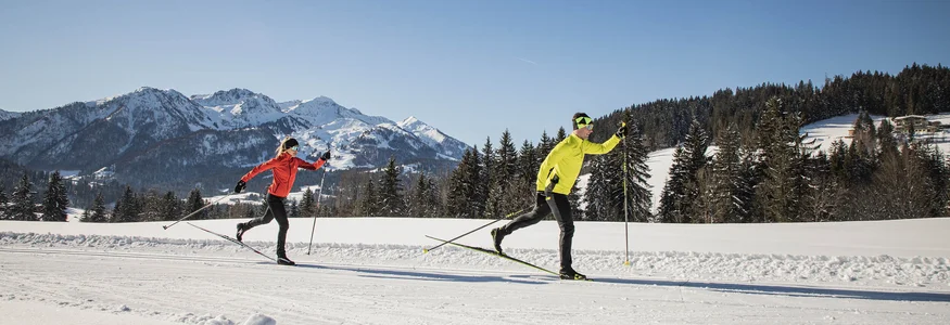 PillerseeTal © Mirja Geh Two people cross-country skiing on snow with mountains in background